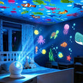 Supplier illustration of a white projector with colorful ocean creatures across a bedroom; projection coverage is illustrative